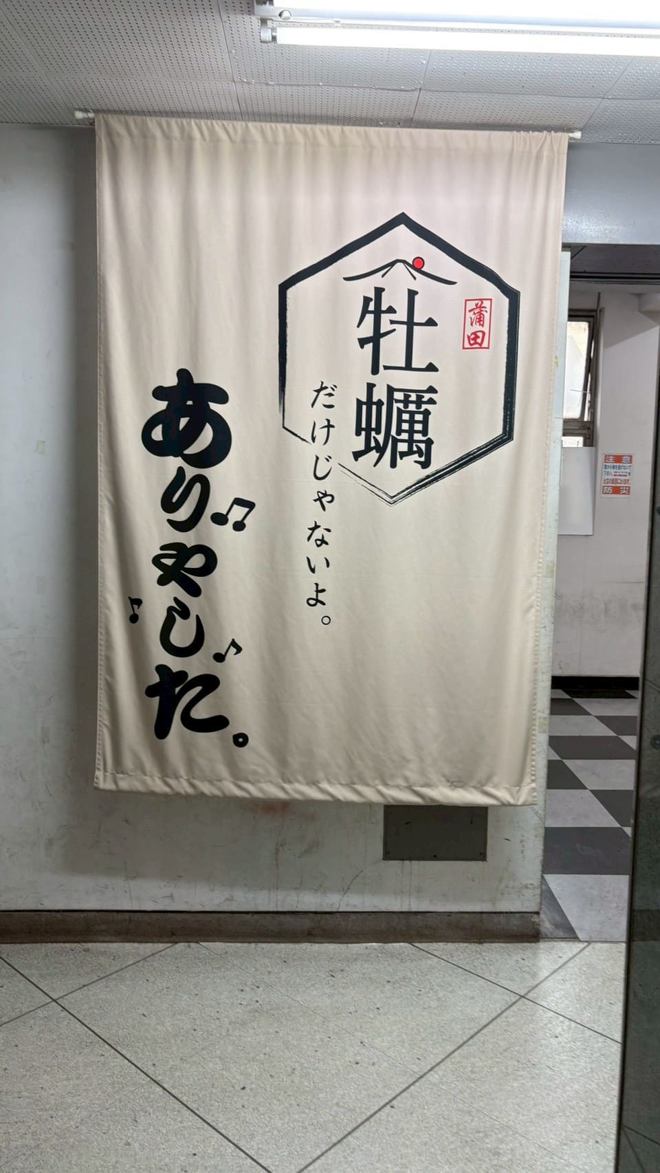 牡蠣だけじゃないよの暖簾がかかった店舗入口