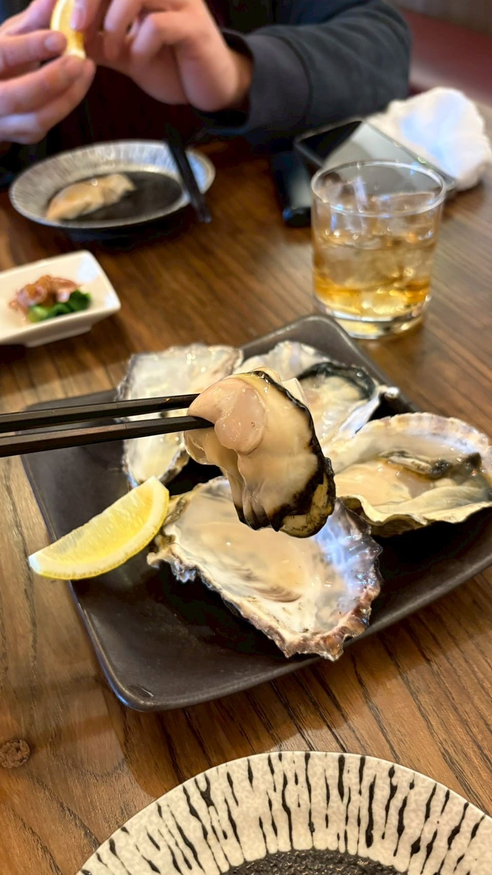 箸で持ち上げたぷりぷりの生牡蠣